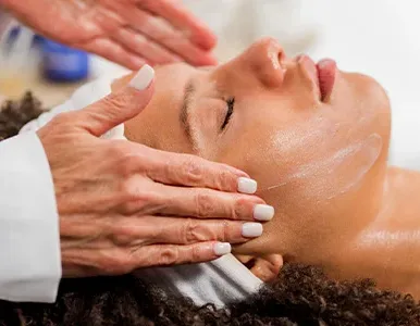 Close-up of a woman with manicured nails holding a mug in a bright, minimalist setting.