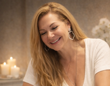 Close-up of a woman with manicured nails holding a mug in a bright, minimalist setting.
